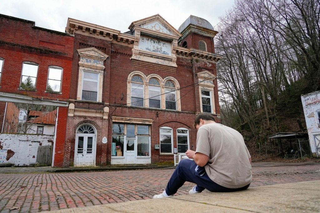 Virginia Tech Architecture Student looking at building in Pocahontas VA. Photo by Lee Friesland